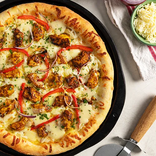 Butter Chicken Pizza with rich butter chicken flavours on hand-tossed crust at Casablanca Pizza & Donair Edmonton